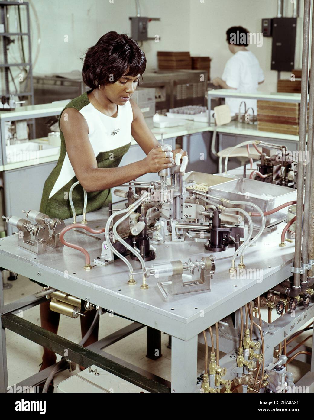 1960s AFRICAN-AMERICAN WOMAN WORKING IN TELEVISION TUBE PLANT HERE SHE IS BEADING A GLASS COLOR FGUN  - ki1350 HAR001 HARS AFRICAN-AMERICANS AFRICAN-AMERICAN PROGRESS SHE BLACK ETHNICITY INNOVATION LABOR EMPLOYMENT MANUFACTURING OCCUPATIONS HIGH TECH BEADING STYLISH EMPLOYEE MANUFACTURE YOUNG ADULT WOMAN HAR001 LABORING OLD FASHIONED AFRICAN AMERICANS Stock Photo