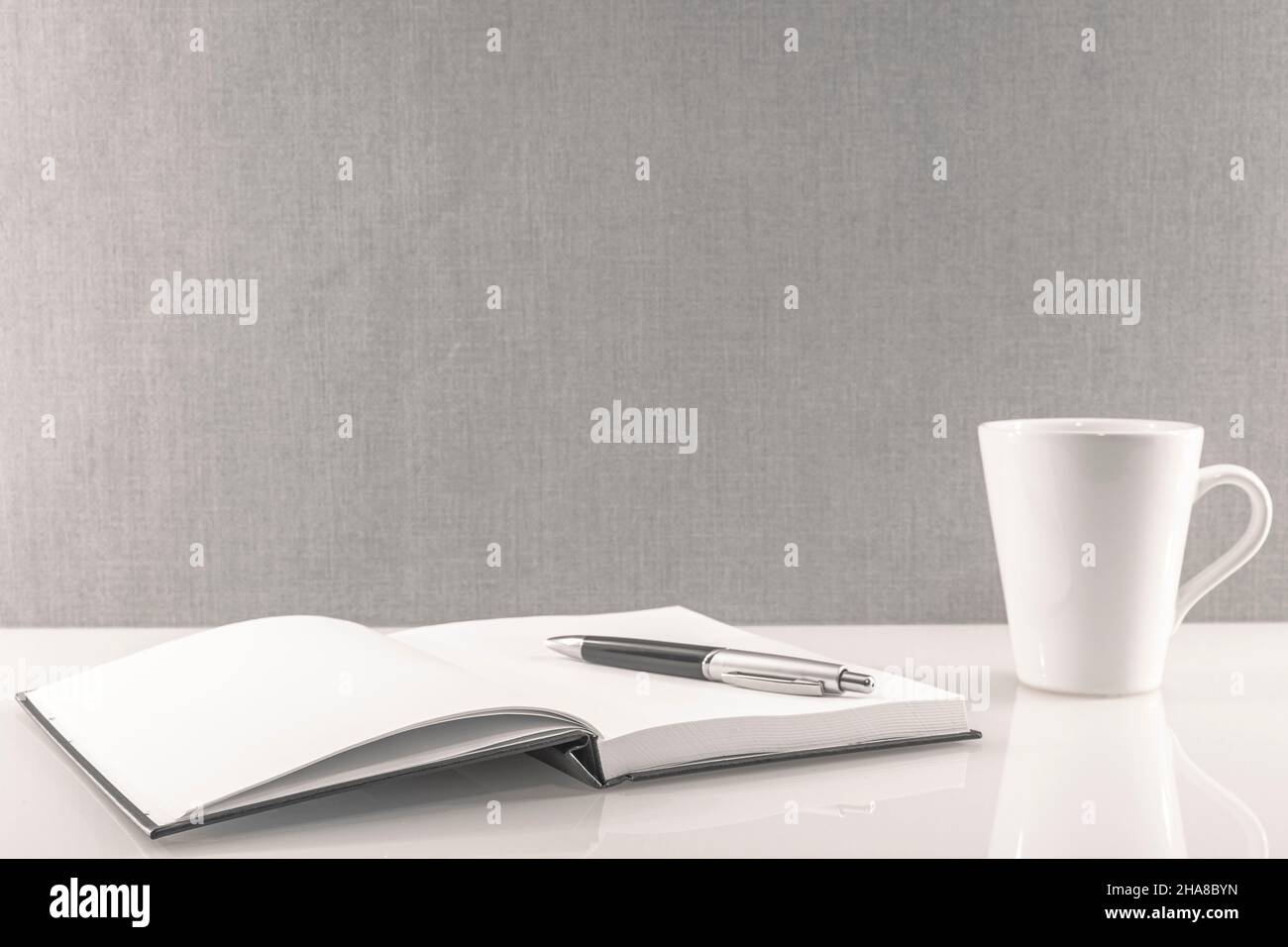 Book opened on a workspace. White pages for inscriptions. Stock Photo