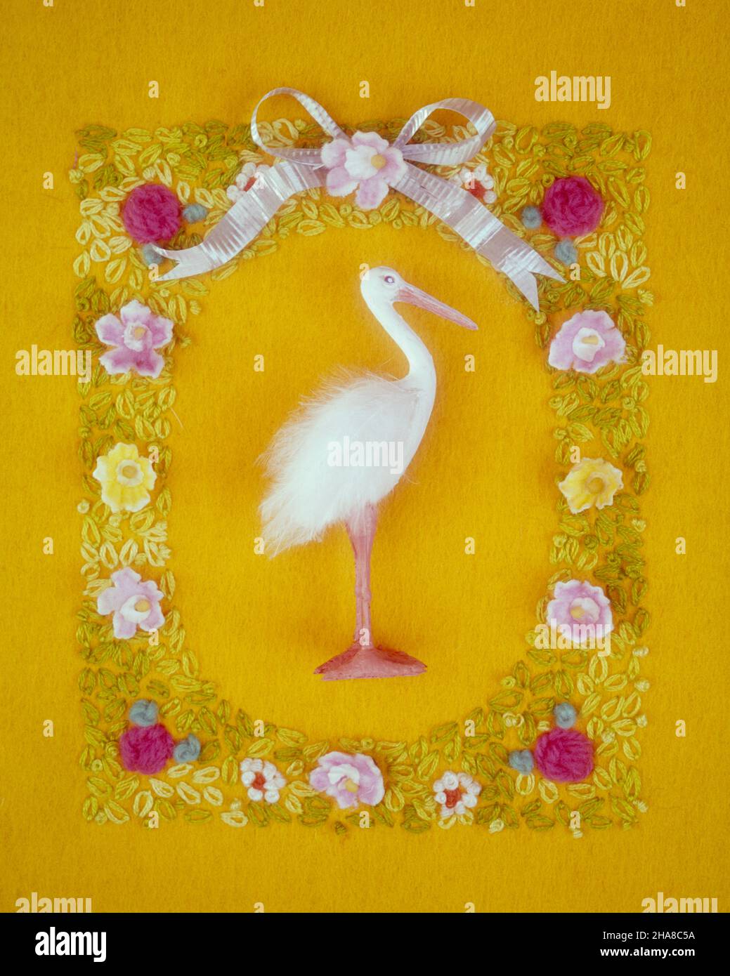 1960s WHITE STORK FIGURE AMID WAX AND EMBROIDERED FLOWERS ON YELLOW FELT TEXTILE SYMBOLIC CHILD BIRTH STILL LIFE ART - ks9325 PHT001 HARS STILL LIFE ANNOUNCEMENT FELT IMAGINATION SYMBOLIC ARRIVAL BIRTH CONCEPTS CREATIVITY FEATHERED WINGED AMID BABY GIRL COMPOSITION EMBROIDERED ICONIC LEGEND OLD FASHIONED REPRESENTATION Stock Photo