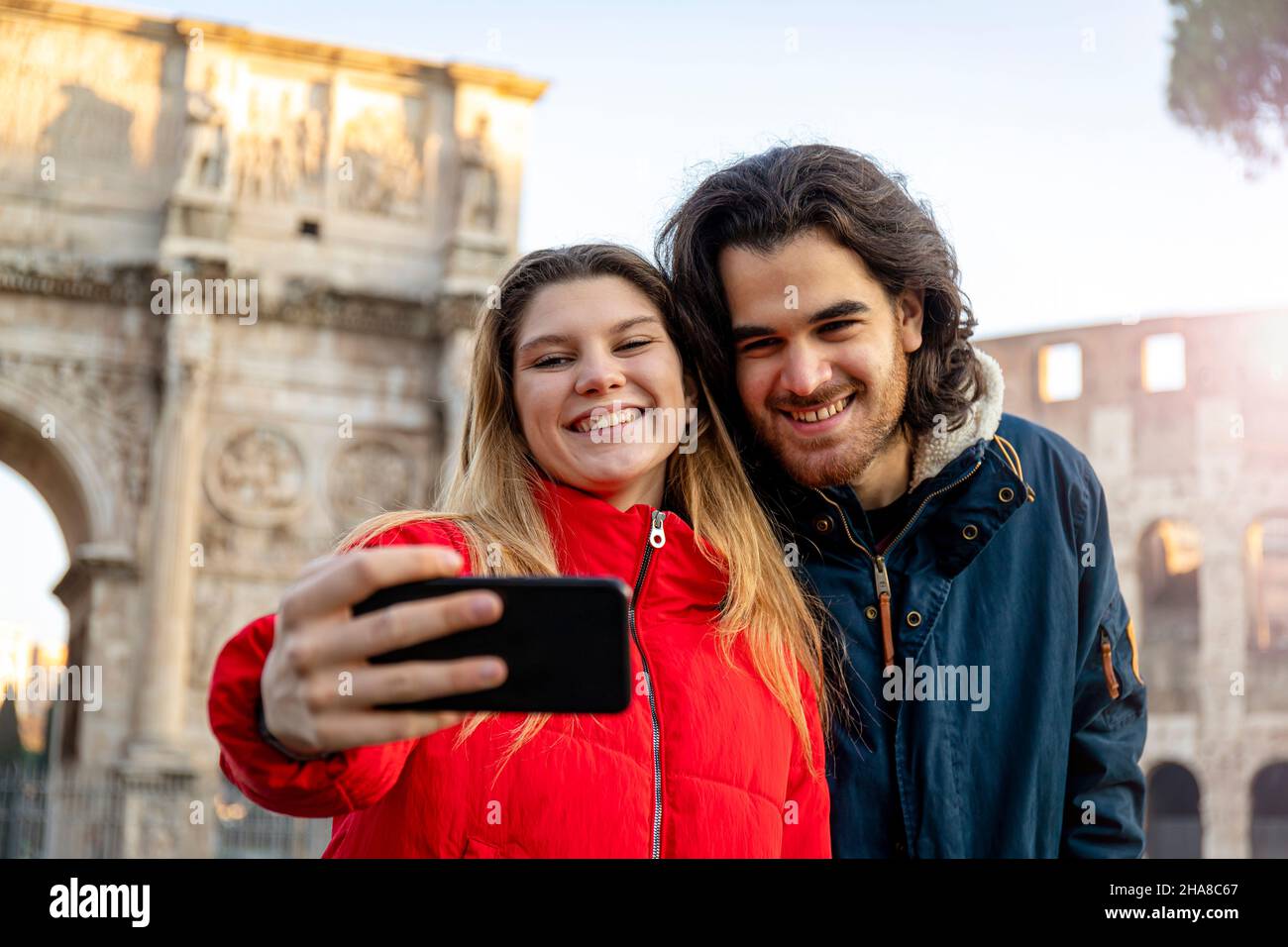 Say cheese! Young charming couple making a selfie in the historical center of Rome, near the Arch of Titus. Stock Photo