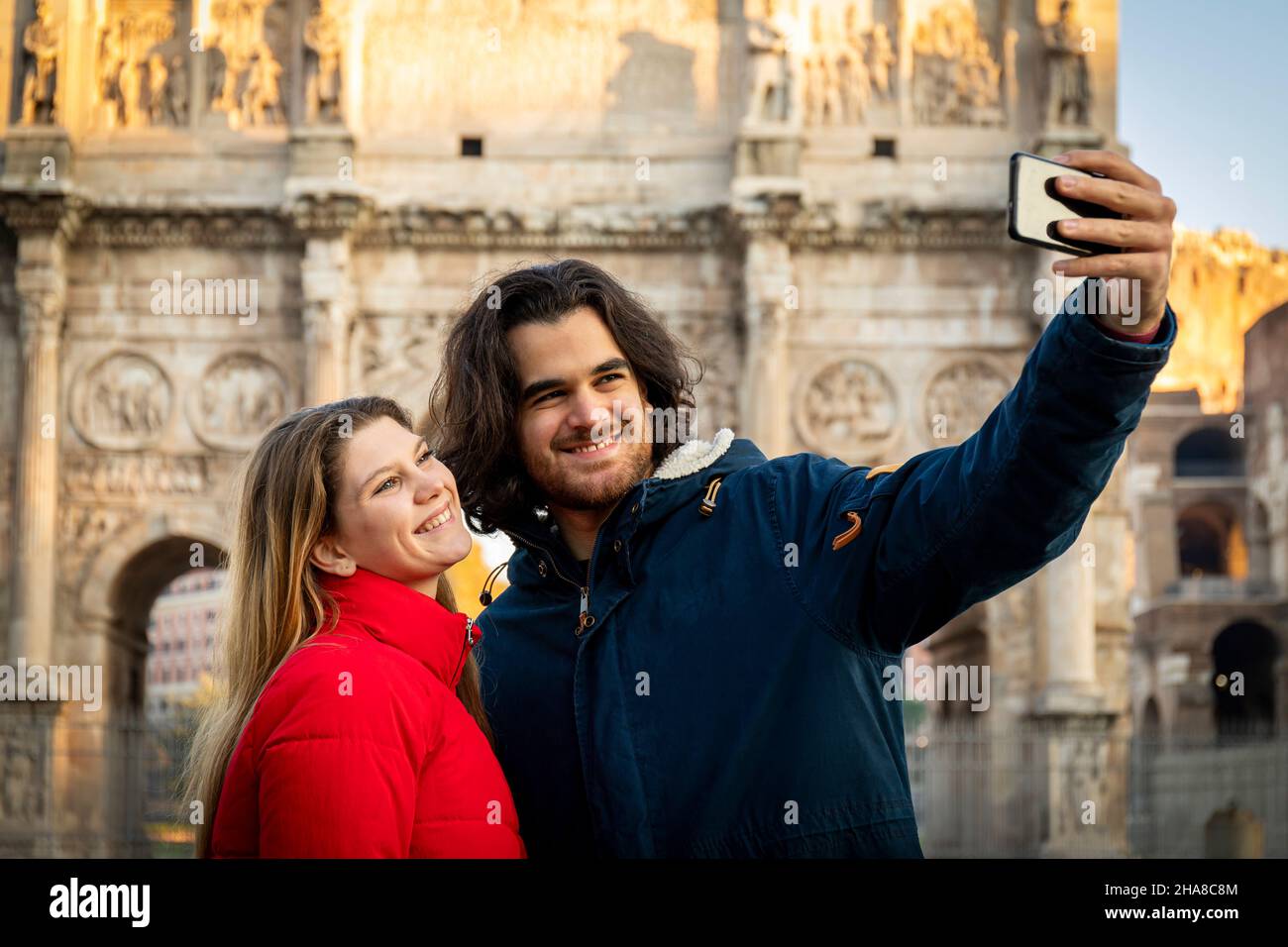 Say cheese! Young charming couple making a selfie in the historical center of Rome, near the Arch of Titus. Stock Photo