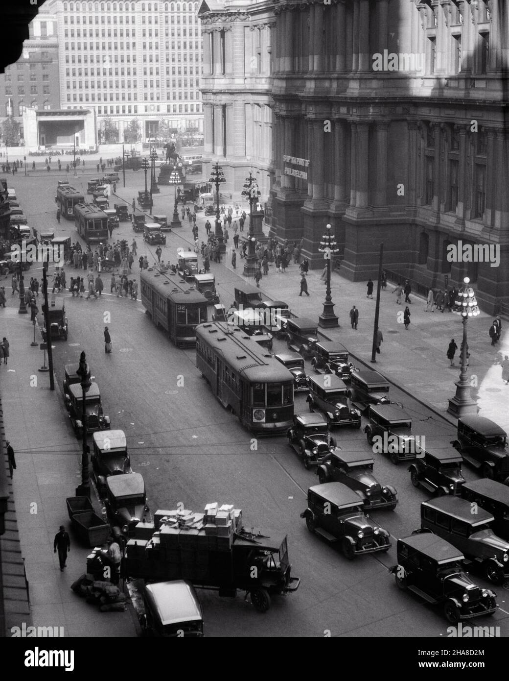 1920s 1930s TROLLEYS CARS TRUCKS TRAFFIC AROUND EAST SIDE OF CITY HALL LOOKING SOUTH PHILADELPHIA PENNSYLVANIA USA - p2547 HAR001 HARS HIGH ANGLE AUTOS EXTERIOR PA TROLLEY COMMONWEALTH AUTOMOBILES CITIES KEYSTONE STATE TROLLEYS VEHICLES STREETCARS TROLLEY BUS BLACK AND WHITE CITY OF BROTHERLY LOVE HAR001 OLD FASHIONED PUBLIC TRANSPORTATION STREETCAR TRAM TROLLEY CAR Stock Photo