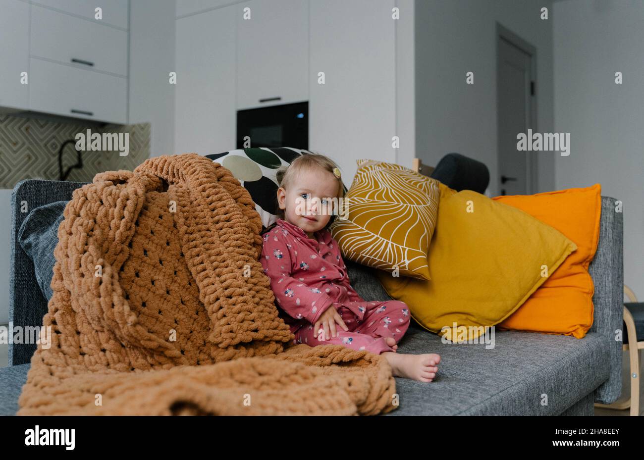 little girl sitting on the couch Stock Photo