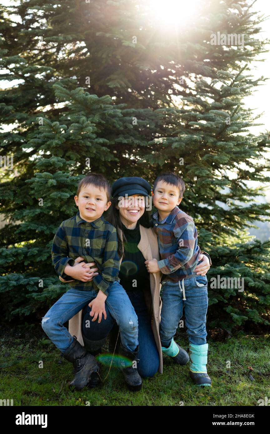 Portrait of mother and sons in front of christmas Tree Stock Photo