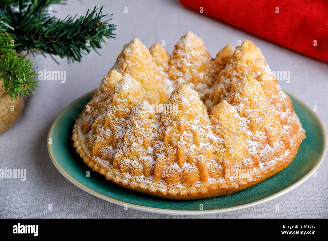 A festive christmas fir tree vanilla cake. The cake is made using a Bundt tin to form the cake batter into the tree shapes. A sprinkle of icing sugar Stock Photo