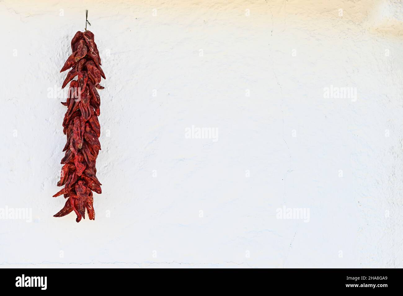 String of red peppers, drying in the sun. Stock Photo