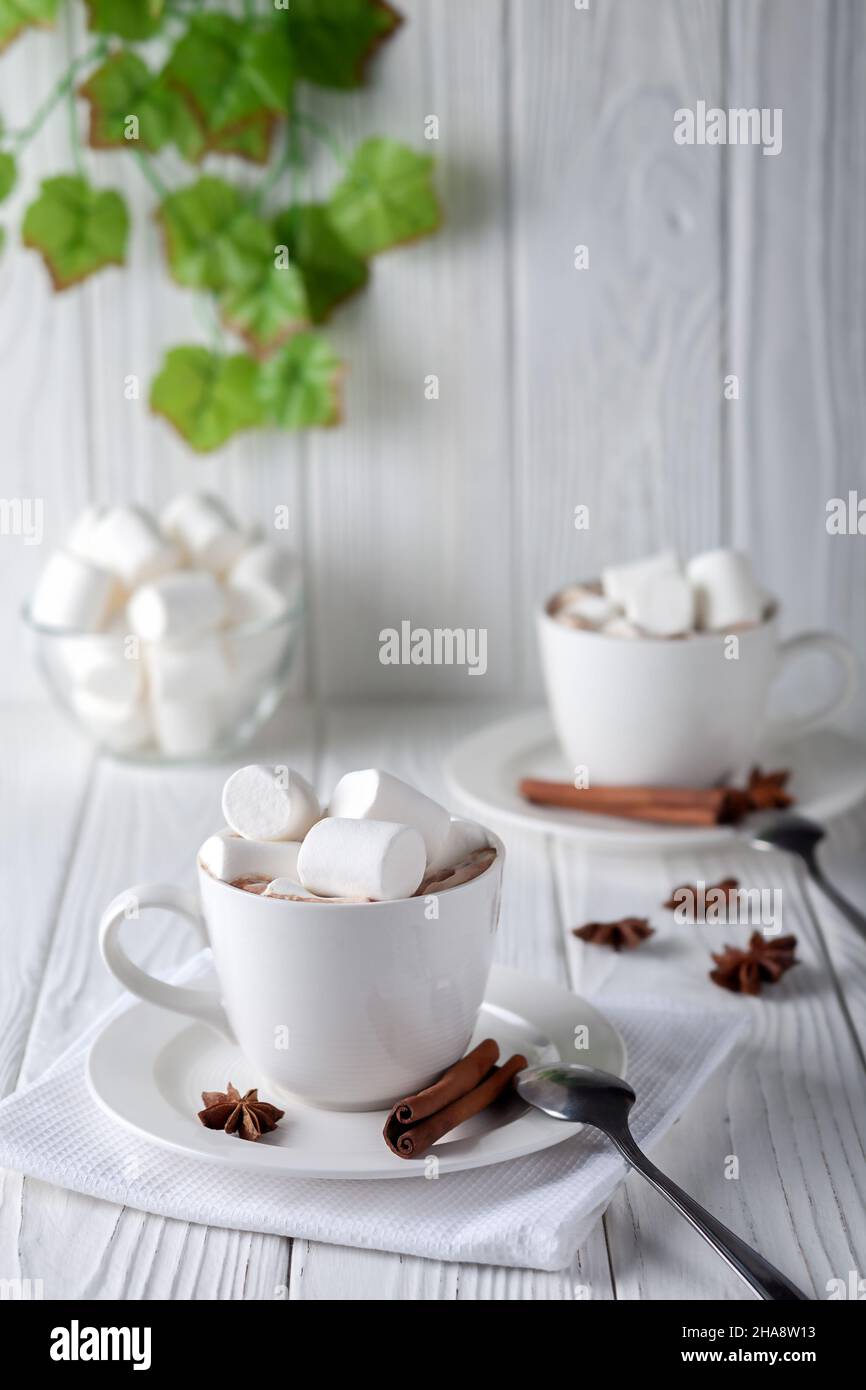 On a white wooden table a mug with hot chocolate and marshmallows Stock Photo
