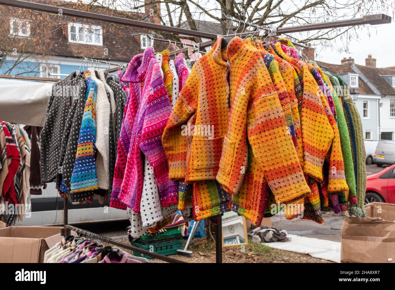 Market stall with brightly coloured woollen jackets, jumpers, cardigans, knitwear, UK Stock Photo