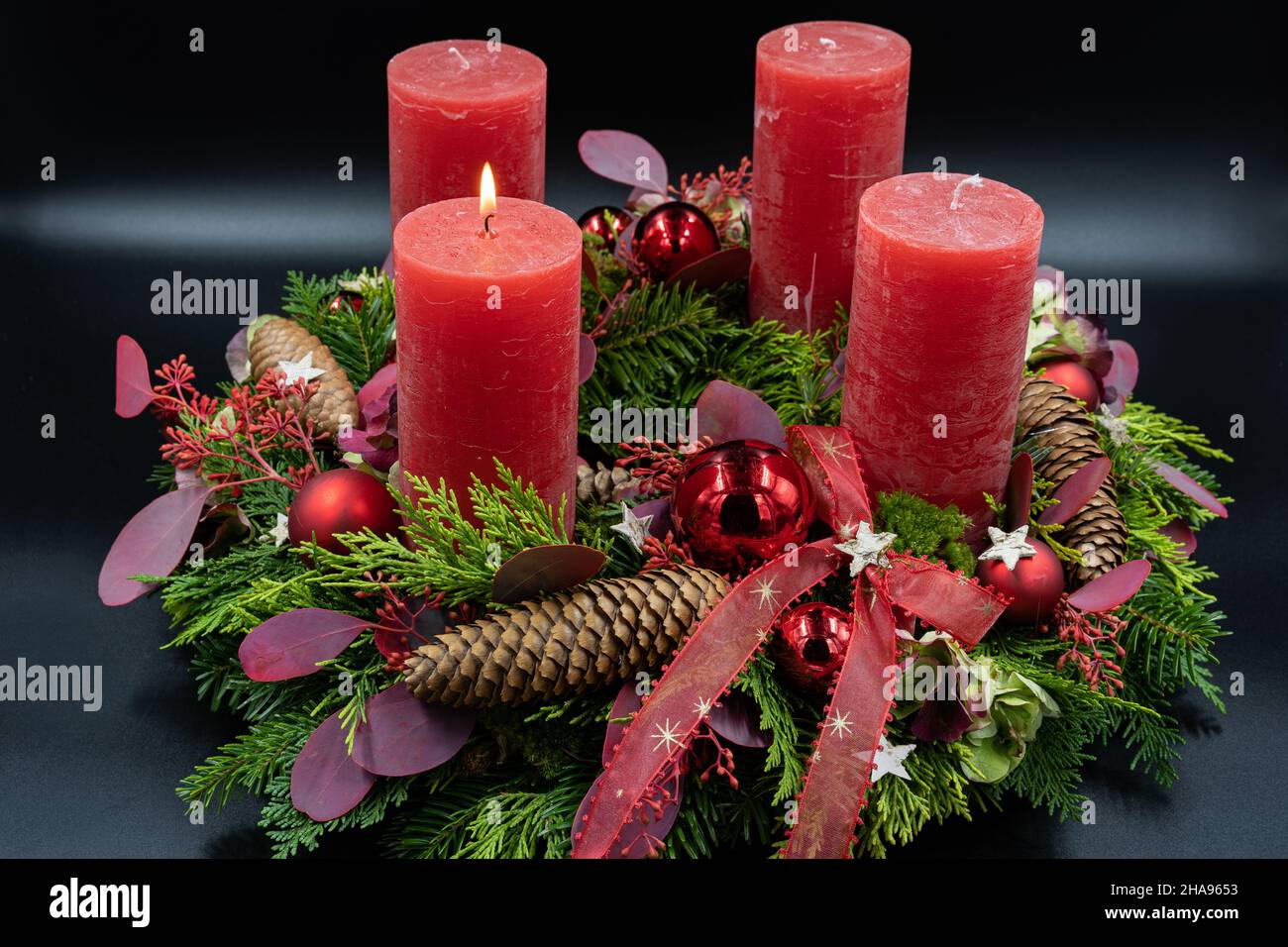 Low angle view of beautiful advent wreath with one burning candle on black background Stock Photo