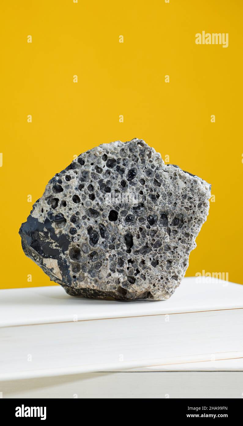 Meteorite rock on textbook, with light brown background. Stock Photo