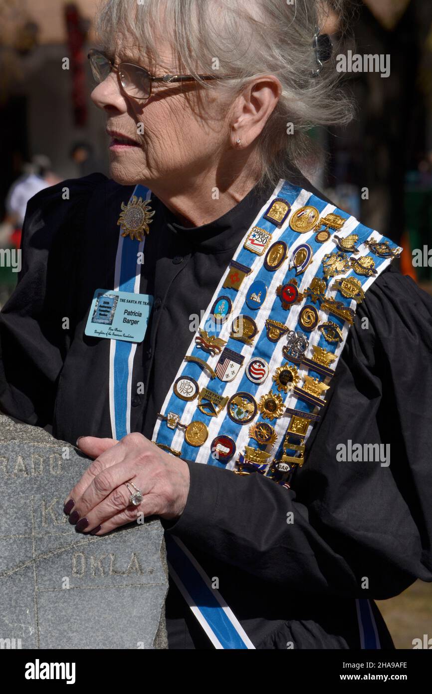 A member of the Daughters of the American Revolution wears her DAR pins, ribbons and sash at a commemorative event in Santa Fe, New Mexico. Stock Photo
