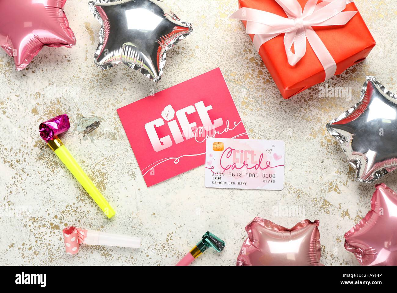 Gift card, whistles, balloons and present on light background Stock