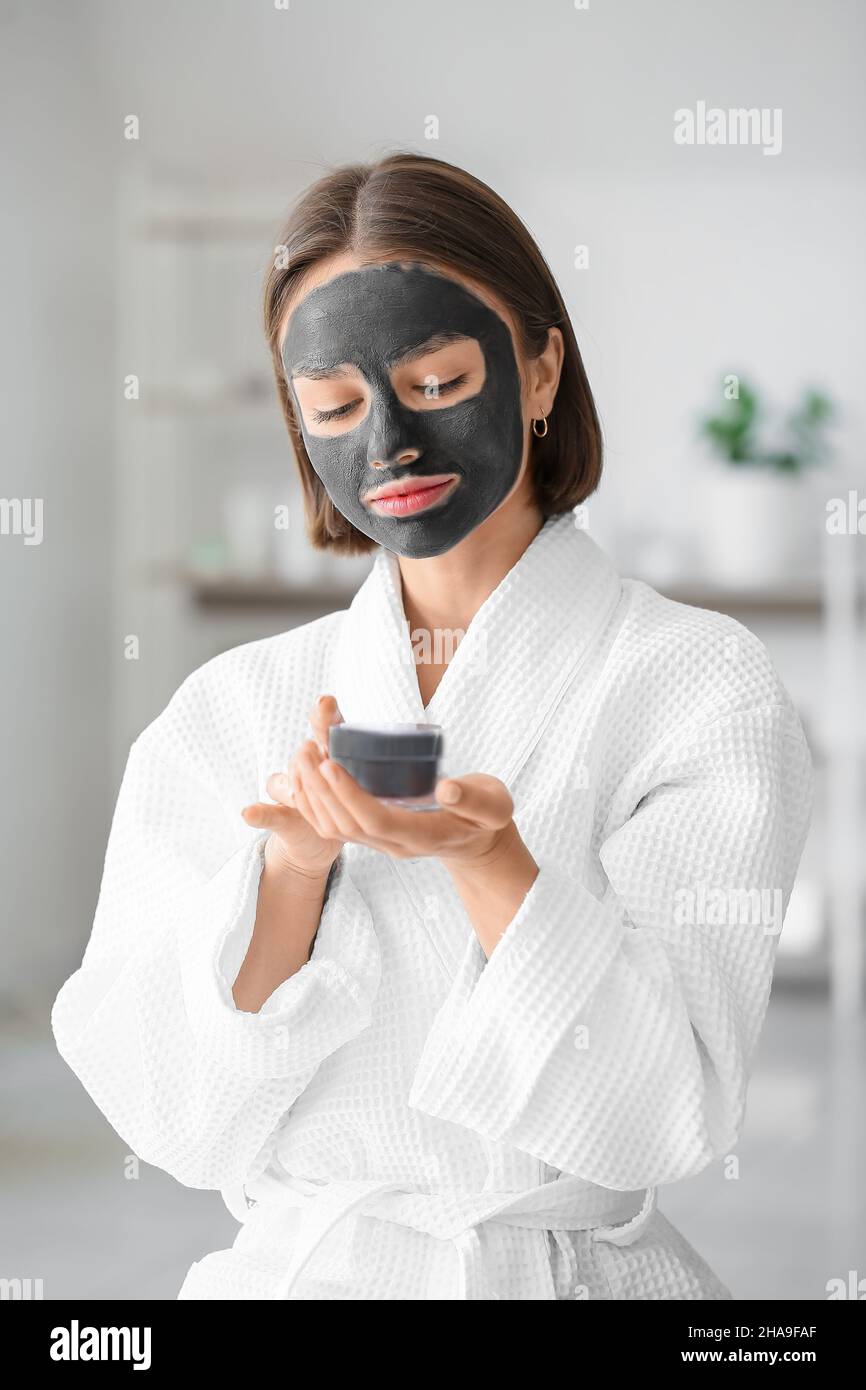 Young woman with activated charcoal mask on her face at home Stock Photo -  Alamy