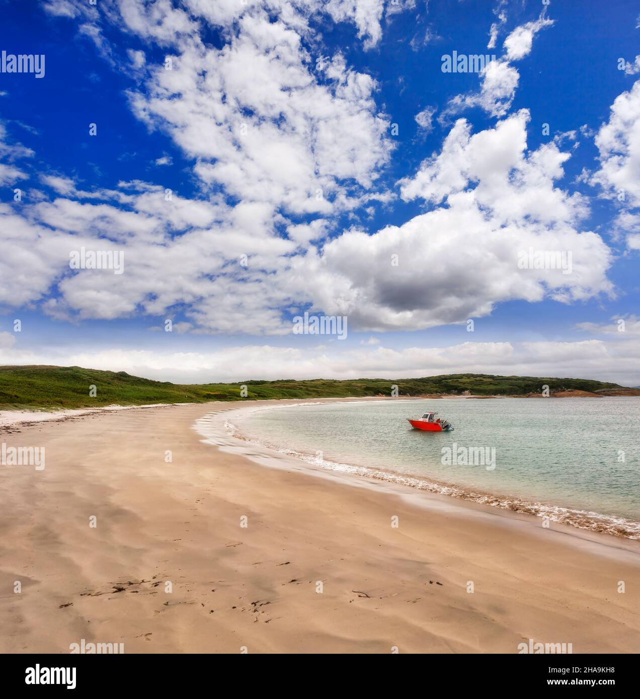 Small fishing boat on pristine waters of Providence bay and beach at Broughton island - Australian pacific coast. Stock Photo