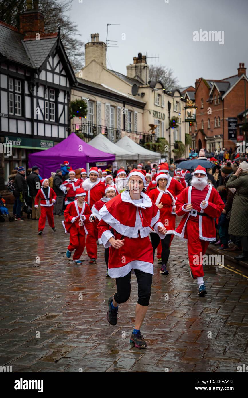 December 11th 2021 - Lymm Village, Cheshire, England, UK. The annual Santa Dash has returned to Lymm Village following a break because of COVID 19. It rained all day. The run happens before the Grand Parade at the Lymm Dickensian Christmas Festival where there will be a range of stalls and merchants selling a variety of arts and crafts and Christmas gifts, along with a wide selection of food, line the village streets with Dickensian characters in abundance. Credit: John Hopkins/Alamy Live News Stock Photo