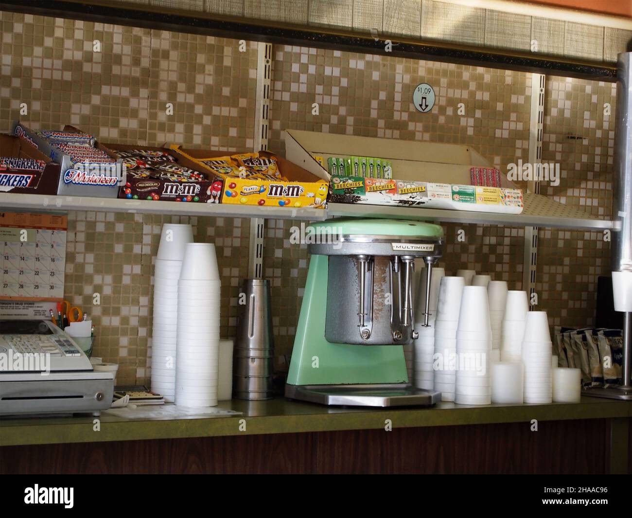 MORGANTOWN, WV - AUGUST 28, 2014: A vintage 1960's Multimixer milkshake blender stands on an old fashioned soda counter with stacked styrofoam cups an Stock Photo