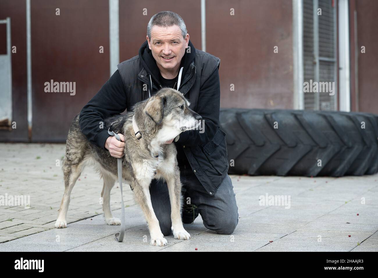 Kassel, Germany. 10th Dec, 2021. Karsten Plücker, shelter manager, poses with mongrel Zoenette at the 'Wau-Mau-Insel' shelter. Currently, about 80 dogs, 60 cats and 40 small animals such as rabbits or birds are waiting for a new home at the 'Wau-Mau-Insel'. Credit: Swen Pförtner/dpa/Alamy Live News Stock Photo