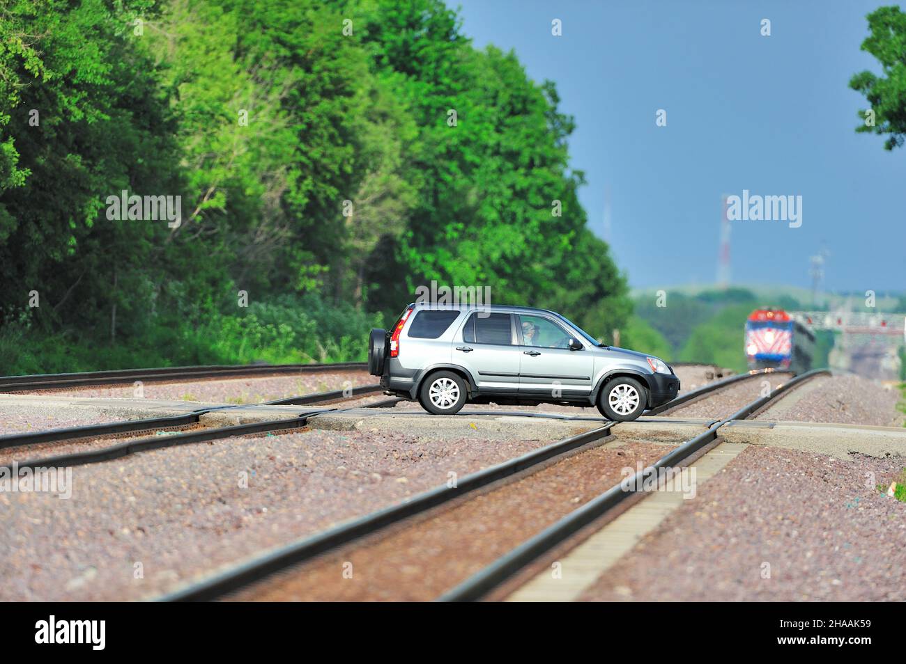 LaFox, Illinois, USA. A vehicle going over Union Pacific tracks as a Metra commuter train bares down on the country grade crossing. Stock Photo