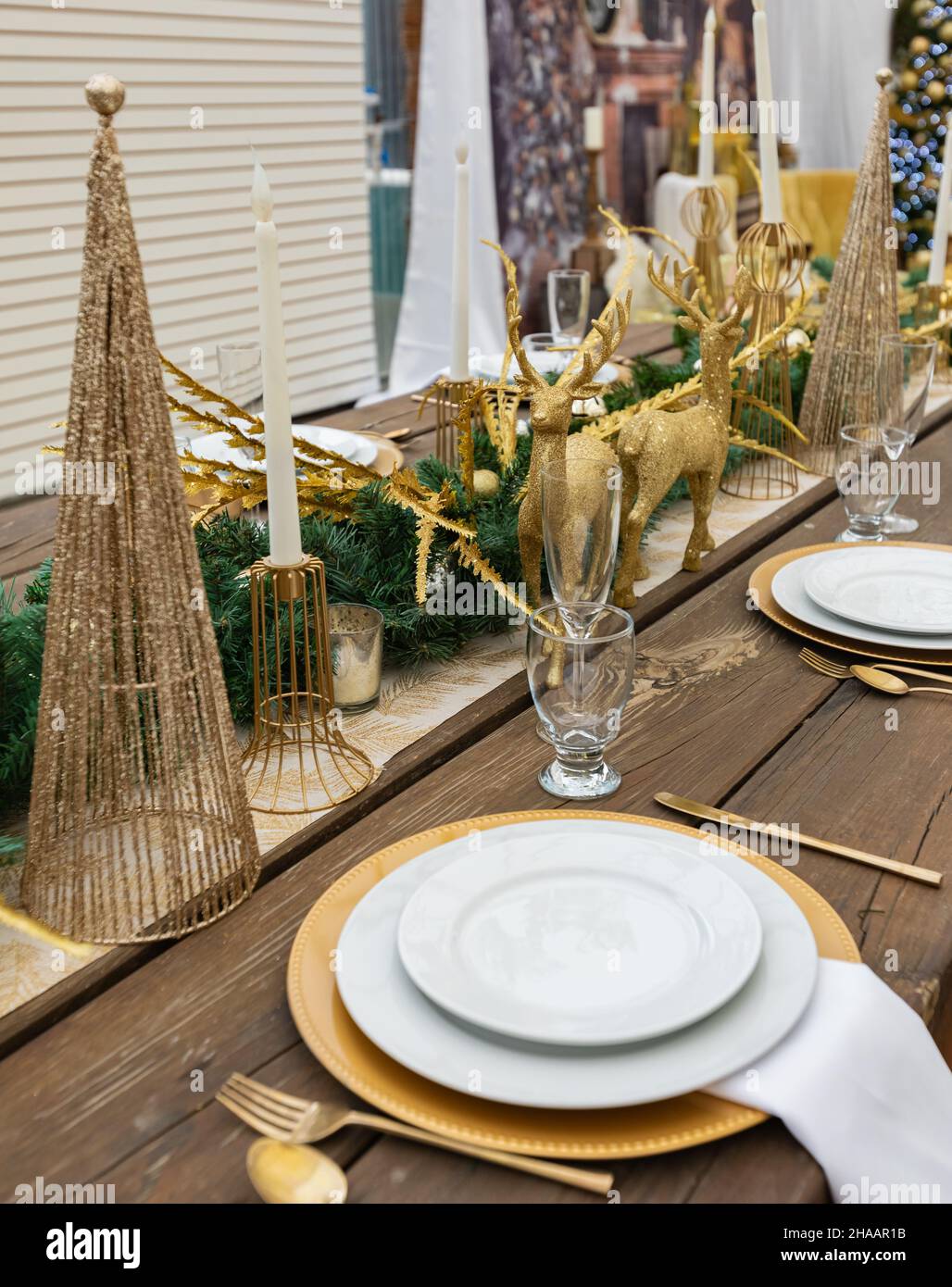 Rustic christmas served table. Table served for Christmas dinner in living room. Christmas table setting with festive decorations. Nobody, selective f Stock Photo