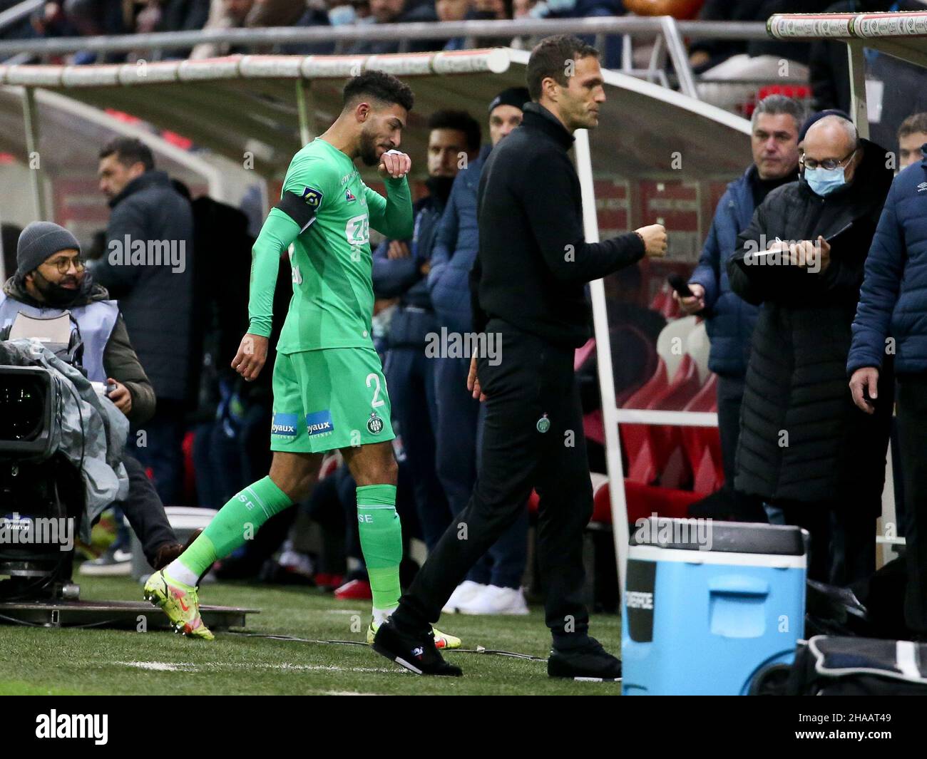 Denis Bouanga of Saint-Etienne leaves the pitch after receiving a red card while coach of AS Saint-Etienne Julien Sable (right) looks on during the French championship Ligue 1 football match between Stade de Reims and AS Saint-Etienne (ASSE) on December 11, 2021 at Stade Auguste Delaune in Reims, France - Photo Jean Catuffe / DPPI Stock Photo