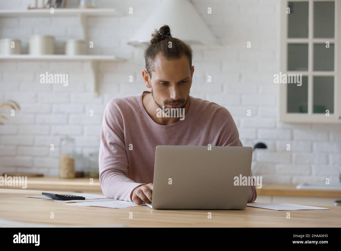 Serious focused millennial tenant man counting domestic fees Stock Photo