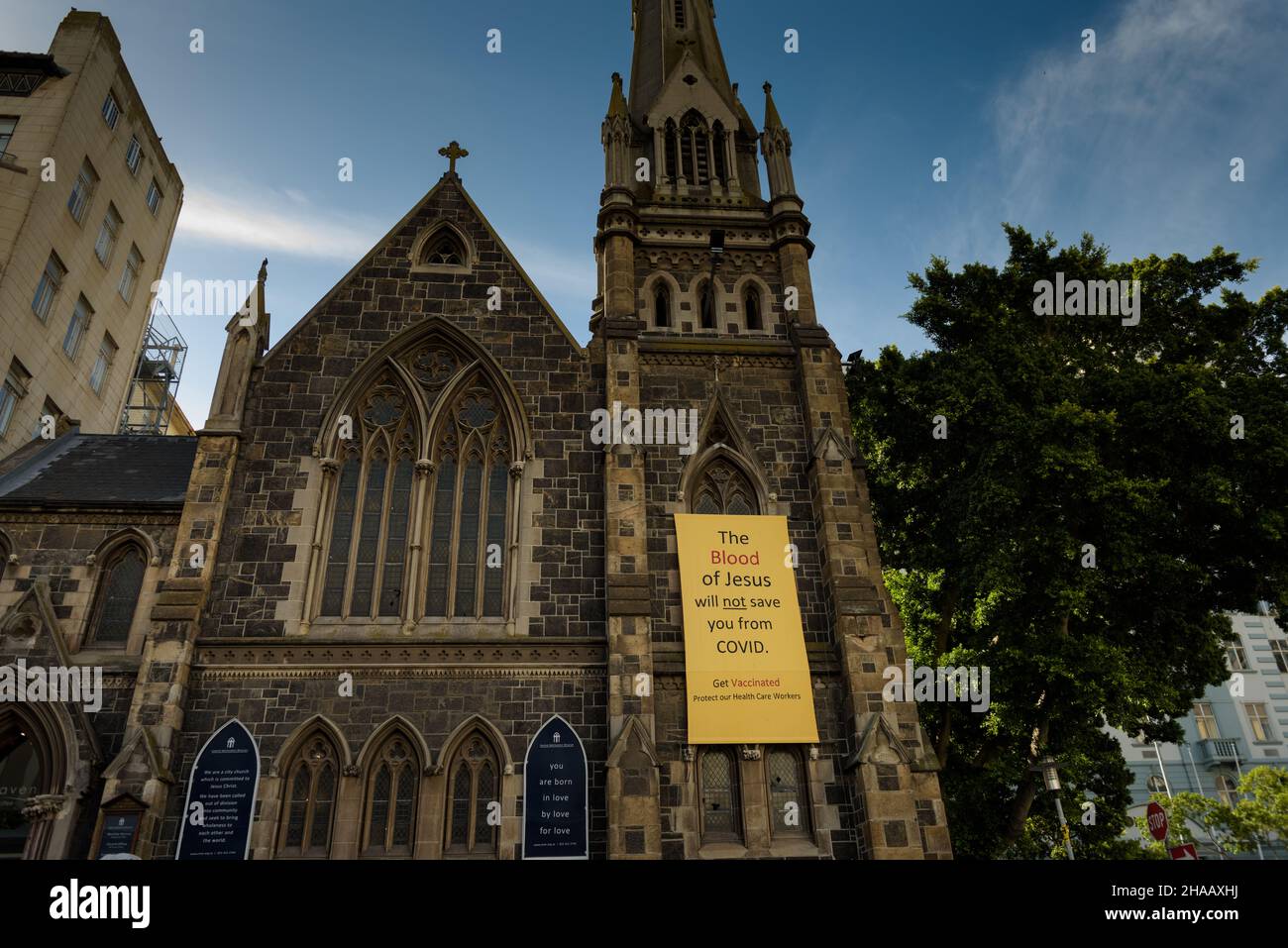 A banner draped on Cape Town's Central Methodist Church advocates  for COVID19 vaccinations and dismisses beliefs that faith can protect from disease Stock Photo