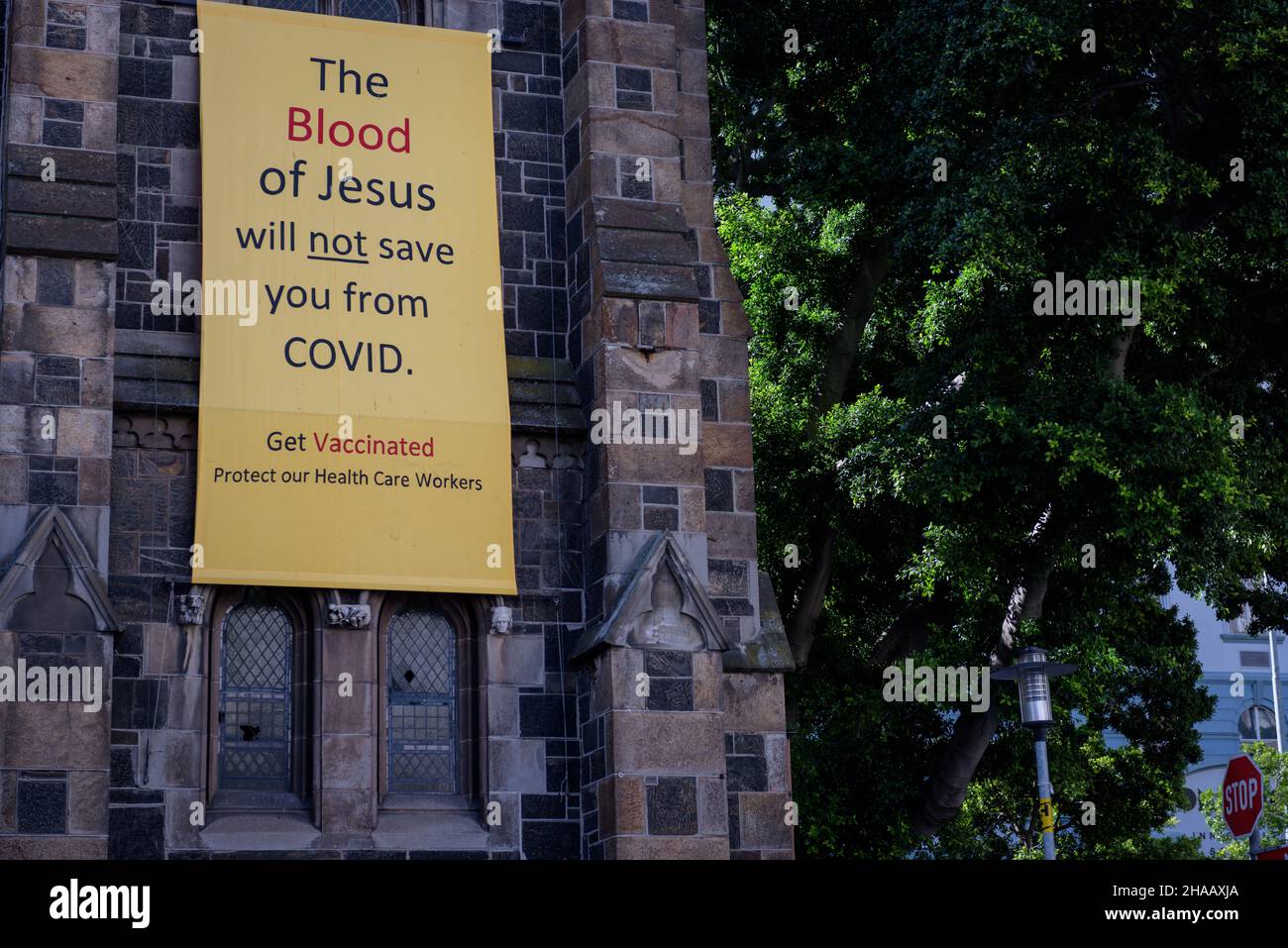 A banner draped on Cape Town's Central Methodist Church advocates  for COVID19 vaccinations and dismisses beliefs that faith can protect from disease Stock Photo