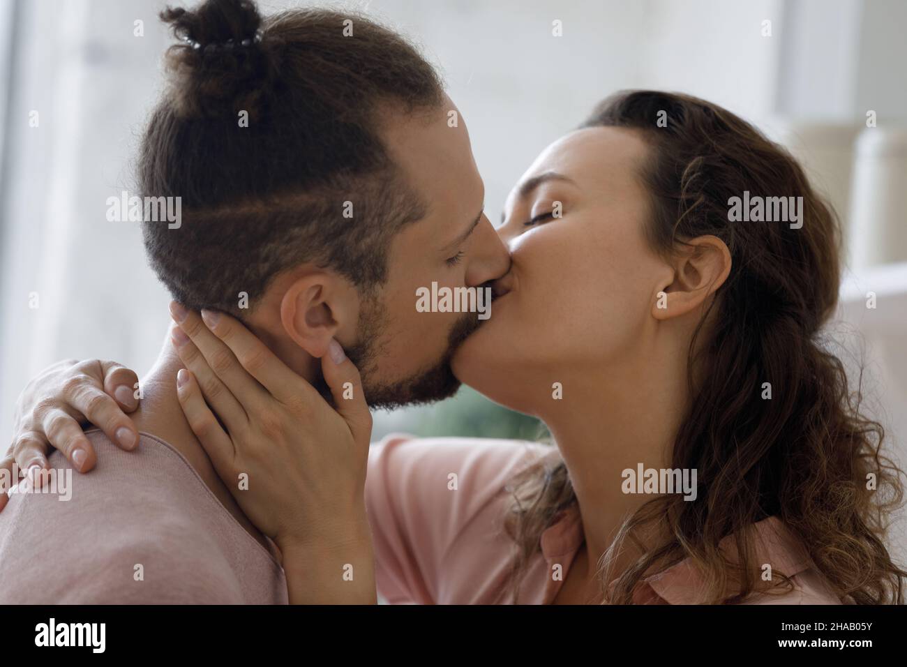 Sweet romantic couple in love kissing on lips at home Stock Photo