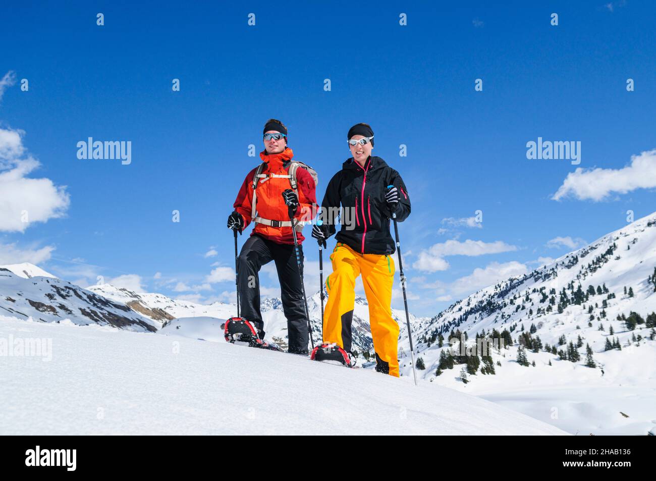 Zwei junge Leute unternehmen gemeinsam eine entspannte Tour auf Schneeschuhen nahe des Körbersees in VoraRelaxed tour with snowshoes in wintry nature Stock Photo