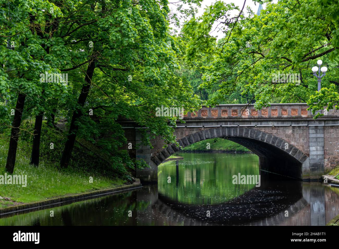 old stone bridge over the canal in the park, urban background with ...