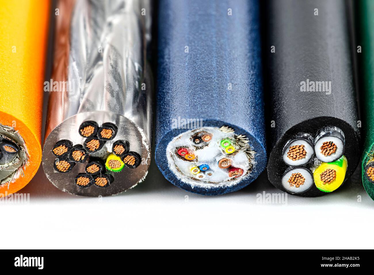 Macro photo of the cross section of various electric cables, isolated on a white background. Stock Photo