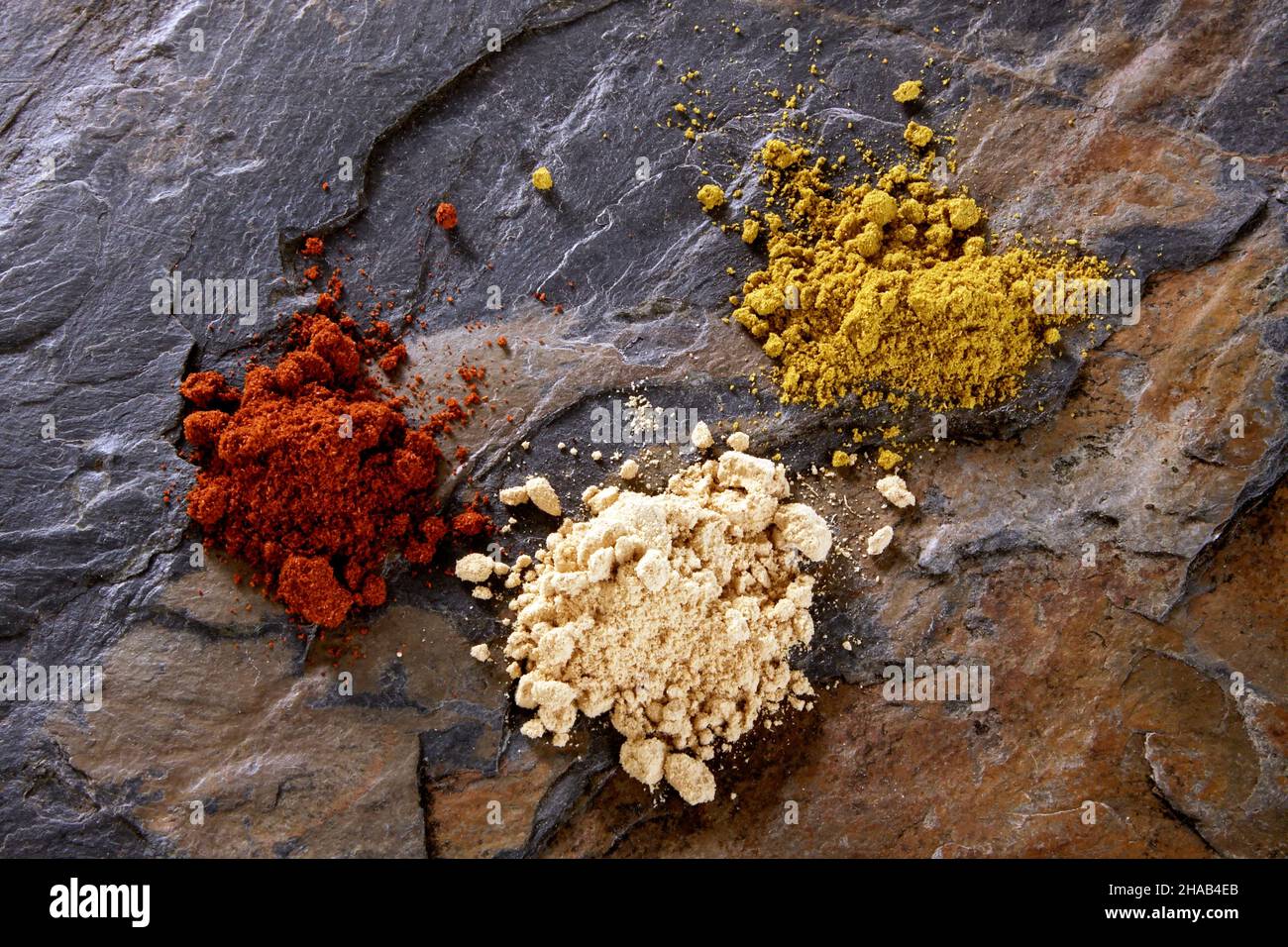 curry, pepper, cayenne pepper, ginger from above on stone surface Stock
