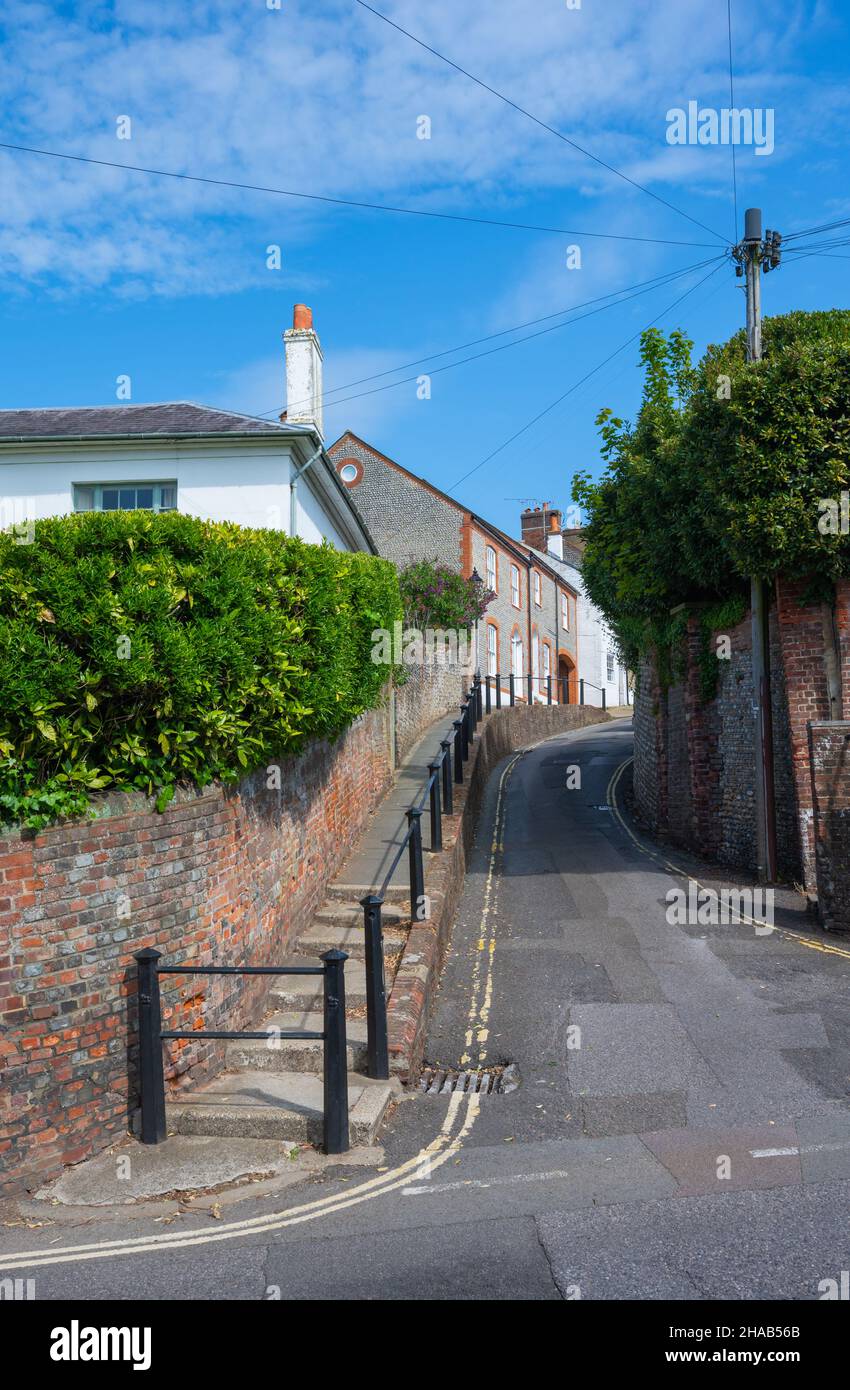 Narrow pavement with steps and safety railings next to narrow road or street on a steep hill in King Street, Arundel, West Sussex, England, UK. Stock Photo