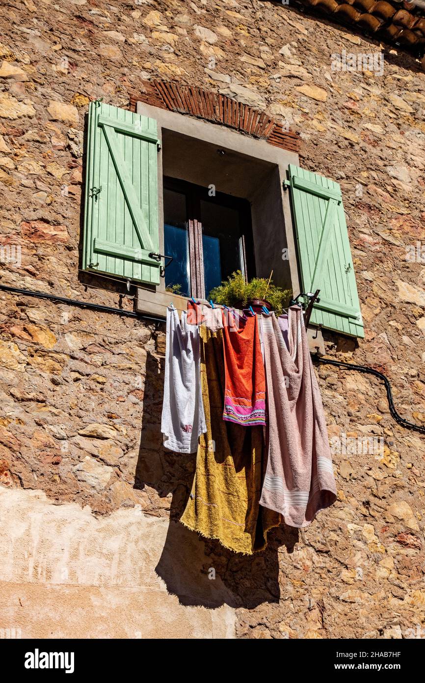 Clothes drying in the sun on a house balcony in Cessenon Sur Orb