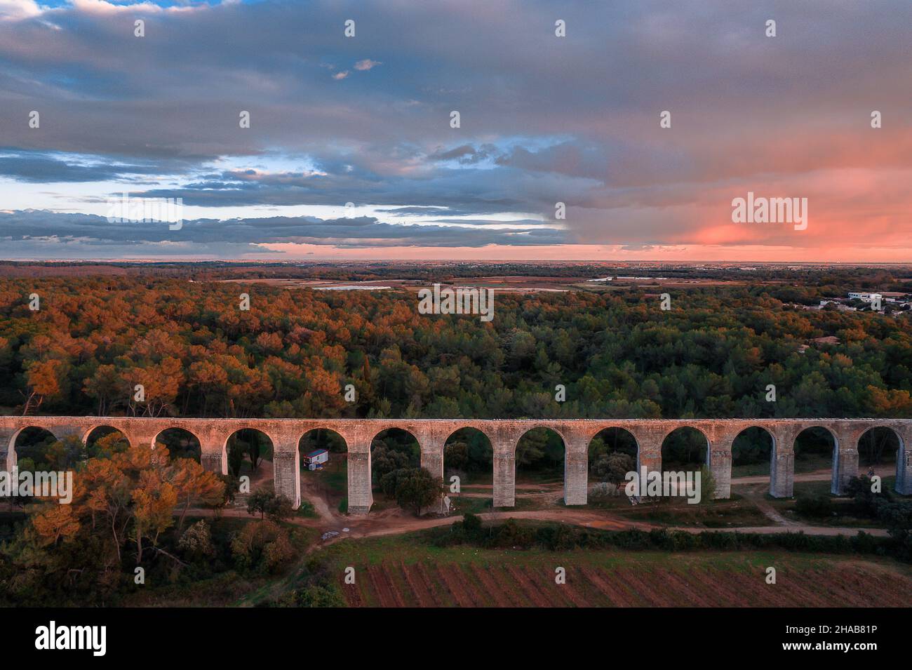 Aerial view of the ancient roman aqueduct within the forest at dusk in ...