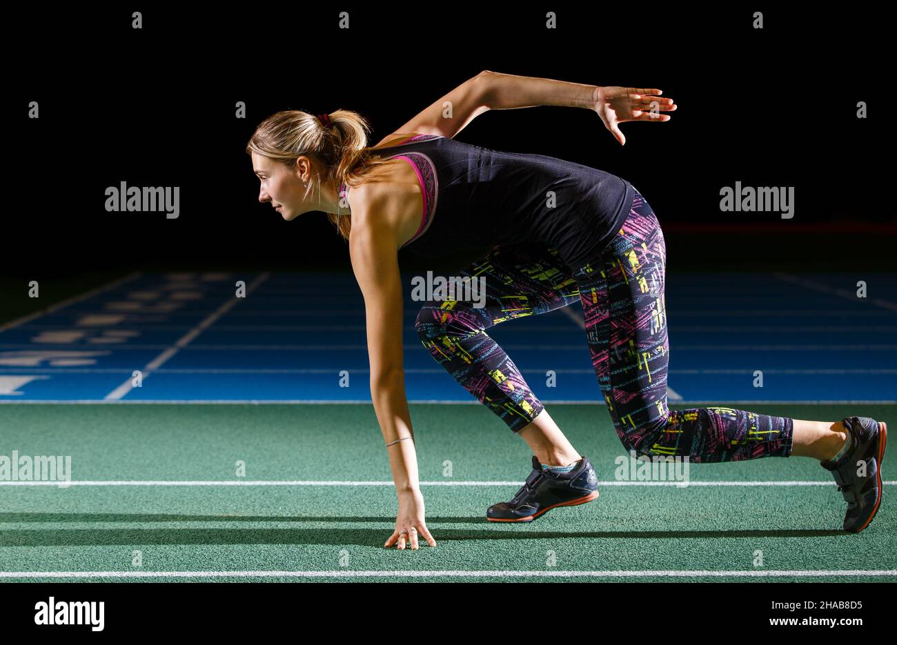 Young female long jump athlete training on track and field arena Stock Photo