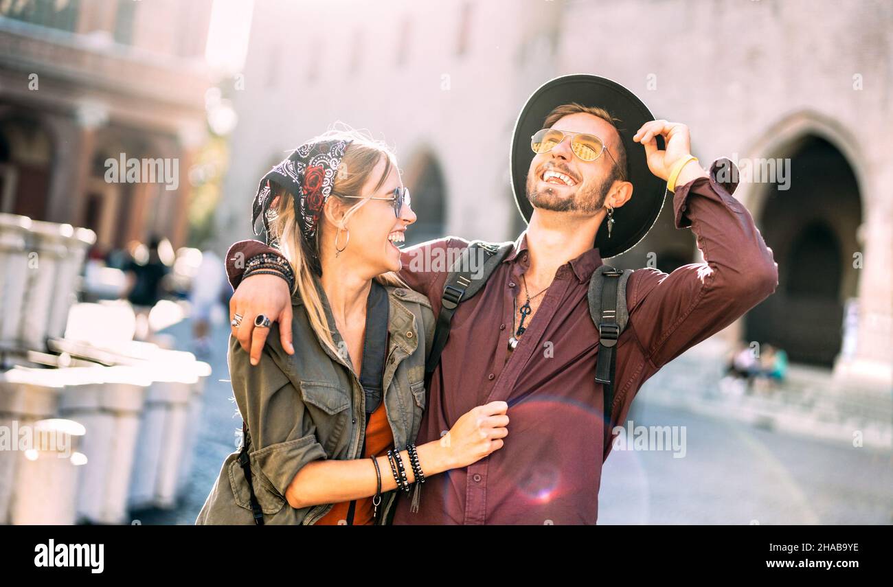 Happy couple in love having candid fun walking in city center - Wanderlust life style and travel vacation concept with guy and girl at old town tour Stock Photo