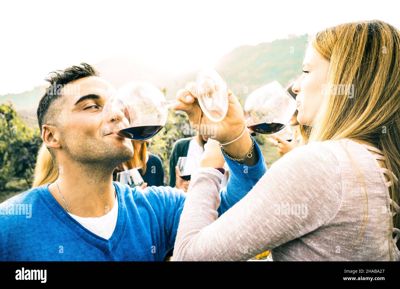 Happy couple in love toasting red wine at vineyard farmhouse - Young man drinking and looking at beautiful woman eyes - Unplugged relationship concept Stock Photo