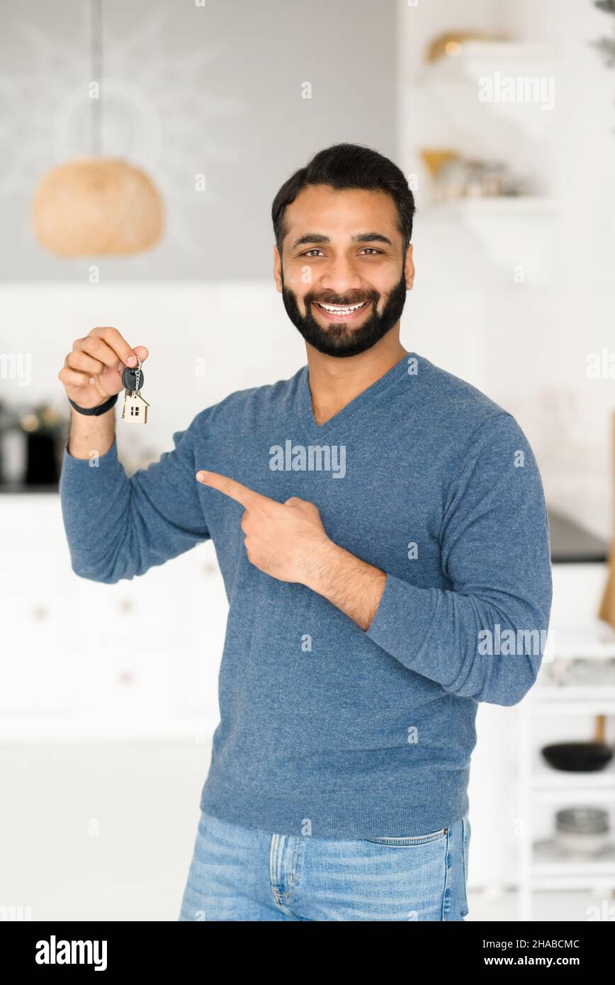 Relocation concept. Excited Indian man moving in new home or apartment