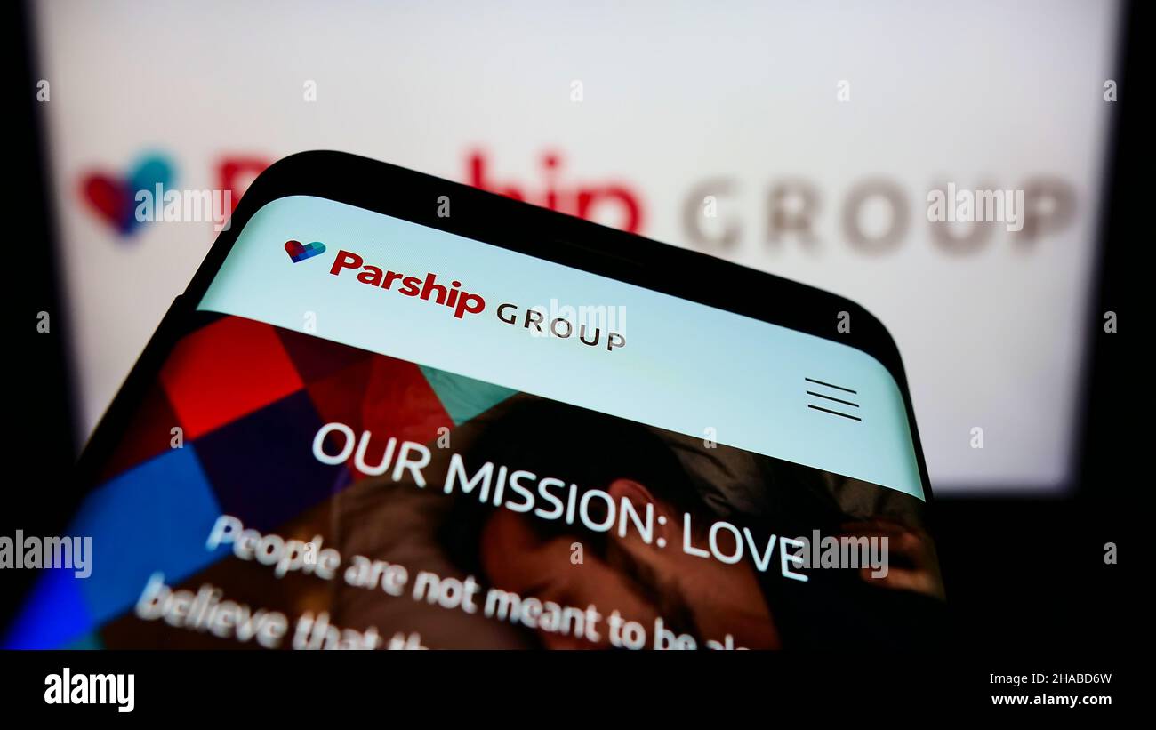 Smartphone with website of online dating company ParshipMeet Holding GmbH on screen in front of business logo. Focus on top-left of phone display. Stock Photo