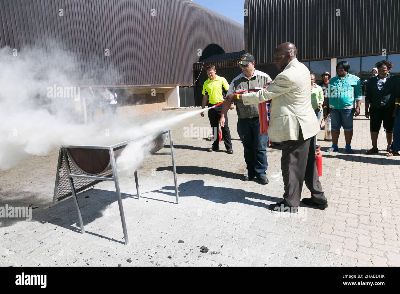 JOHANNESBURG, SOUTH AFRICA - Aug 12, 2021: A shot of practicing fire hazard with a powder-based extinguisher. Stock Photo