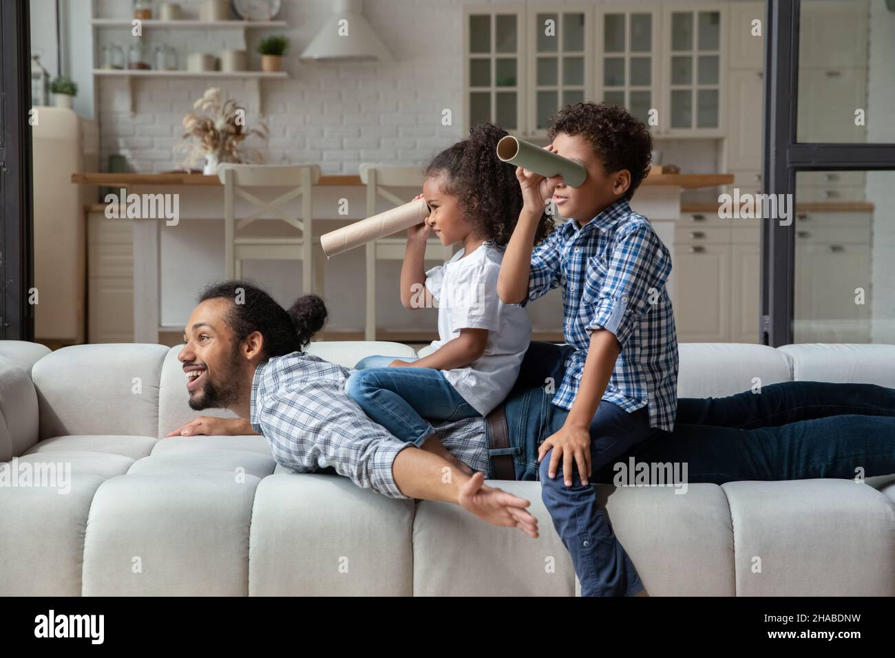 Little kids play explorers with loving father at home Stock Photo