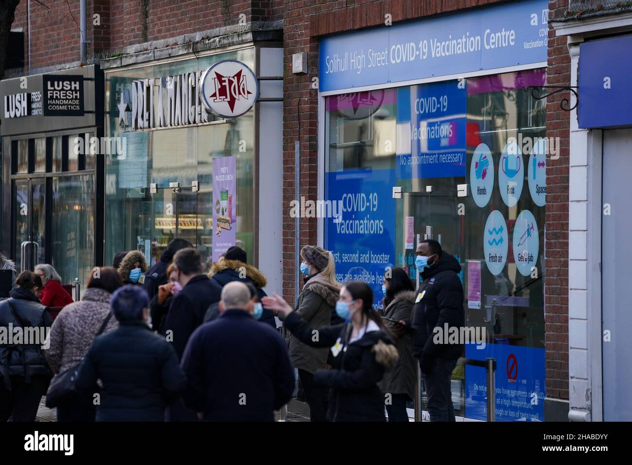 People queue outside a Covid-19 vaccination centre in Solihull. Picture date: Sunday December 12, 2021. Stock Photo