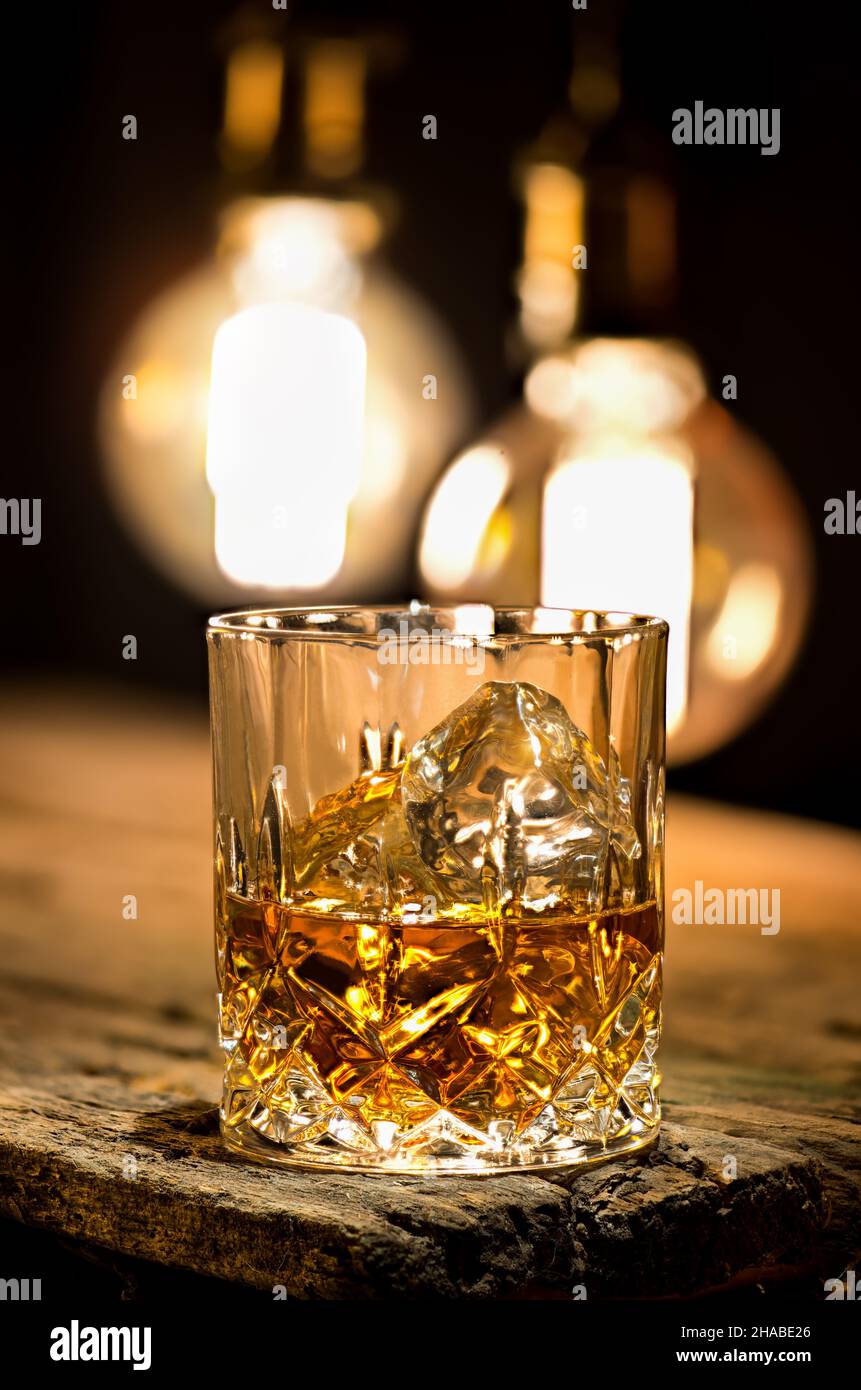 Glass of whiskey lighting with edison lamps Stock Photo Alamy