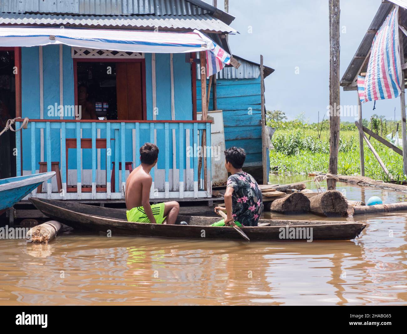 Belen, Peru- Dec 2019: Children on the boat between floating houses in the floodplain of the Itaya River, poorest part of Iquitos - Belén. Venice of L Stock Photo