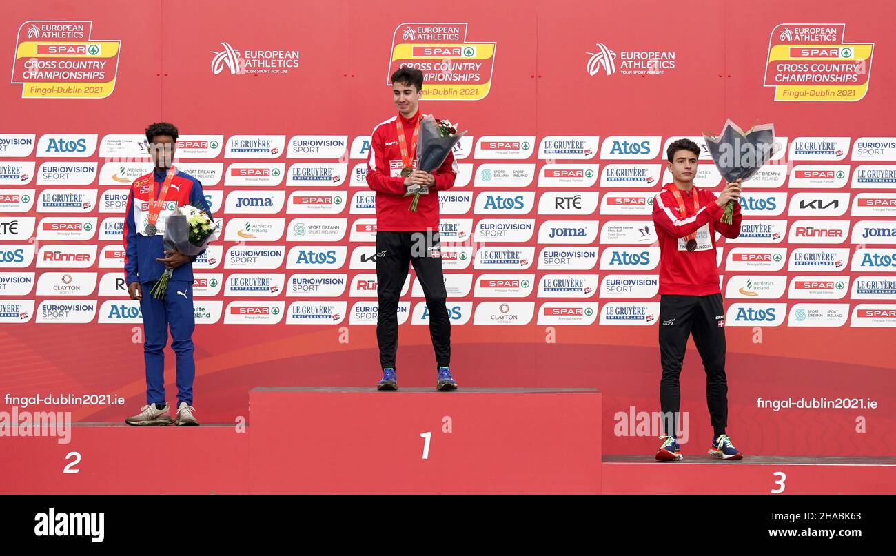 Denmark's Axel Vang Christensen (centre) celebrates on the podium after winning the Under 20's Men's event alongside second placed Norway's Abdullahi Dahir Rabi (left) and third placed Denmark's Joel Ibler Lilleso during the SPAR European Cross Country Championships 2021 at Fingal-Dublin in Ireland. Picture date: Sunday December 12, 2021. Stock Photo