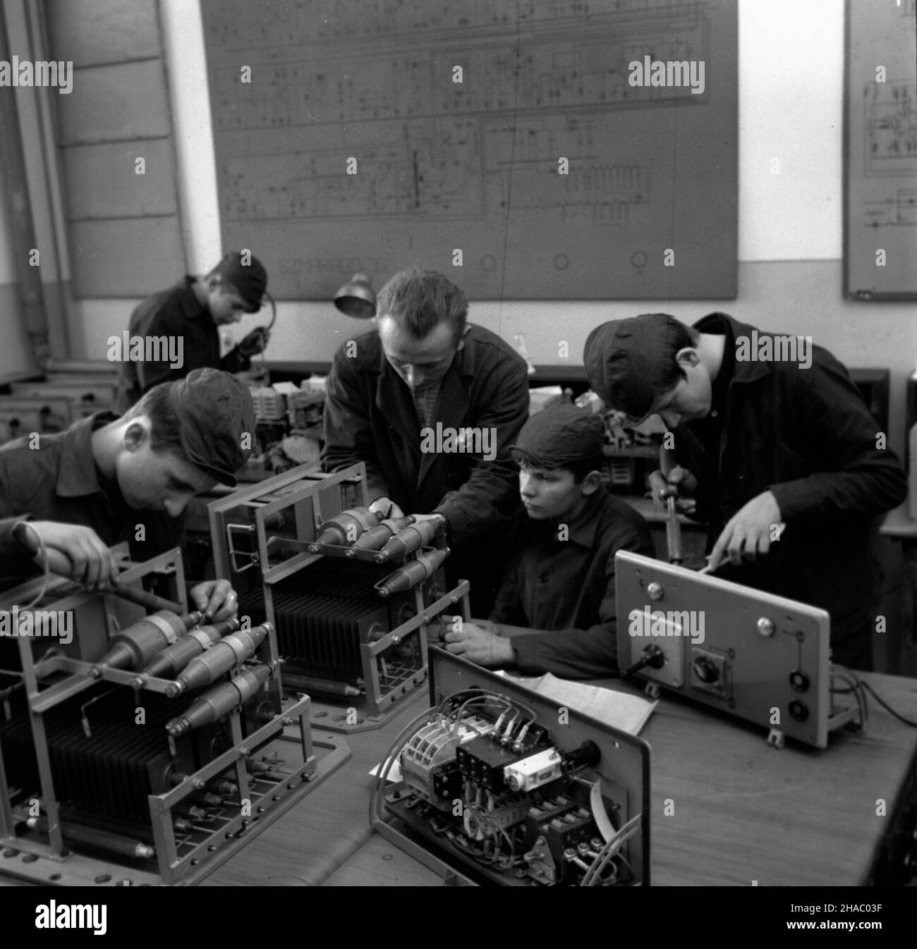 Rzeszów, 1969-11-17. Praktyki w warsztatach Zasadniczej Szko³y Zawodowej, która jest kuŸni¹ kadr dla przemys³u. Tu szkoli siê m.in. tokarzy, œlusarzy, frezerów, spawaczy , monterów urzadzeñ radiowych i telewizyjnych. Nz. lekcja w pracowni radiowo-telewizyjnej. Uczniowie montuj¹ podzespo³y do elektrodr¹¿arek EDA 40 produkowanych przez WSK w Rzeszowie. Zajêcia prowadzi nauczyciel zawodu Henryk Fularz (C). uu  PAP/Andrzej £okaj    Rzeszow, Nov. 17, 1969. Training at the workshop of the industrial vocational school, the work force source for the industry. The school provides training for turners, Stock Photo