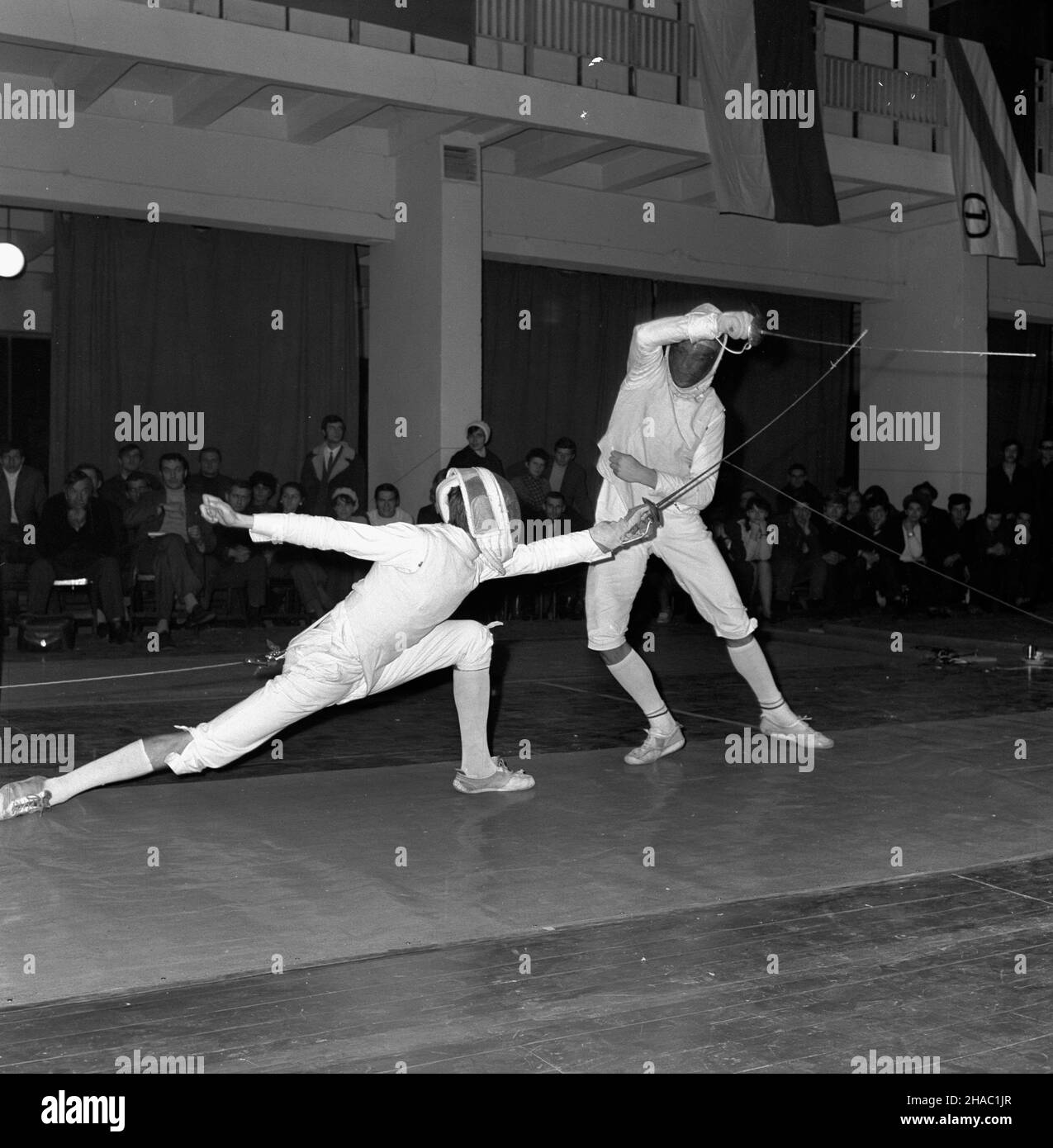 Poznañ, 1969-11-21. Dru¿ynowe Mistrzostwa Polski w szermierce, rozegrane w Poznaniu (Hala Wystawowa nr 20 Miêdzynarodowych Targów Poznañskich) w dniach 21-23 XI 1969 r. Wziê³o w nich udzia³ ponad 30 zespo³ów. W ogólnej punktacji mistrzostw I miejsce zajê³a Legia Warszawa. Nz. pojedynek zawodników. pw  PAP/Zbigniew Staszyszyn      Poznan, Nov. 21, 1969. Poland's team fencing championships held at the Poznan International Fair Hall on November 21-24 with over 30 teams taking part. Legia Warszawa was the winner.  kw  PAP/Zbigniew Staszyszyn Stock Photo