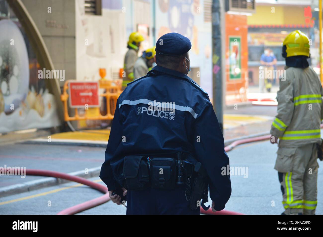 Hong Kong Police Force officer on the scene of a fire in Kwun Tong, Kowloon in December 2021 Stock Photo