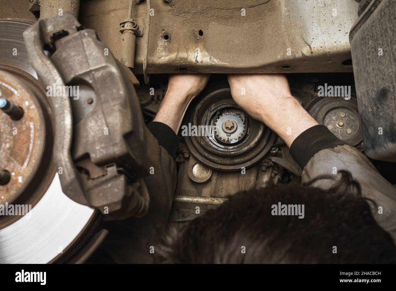 An auto mechanic is repairing a car generator Stock Photo